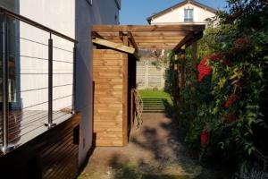 Terrasse en hauteur et aménagement d'un espace bûcher bois.