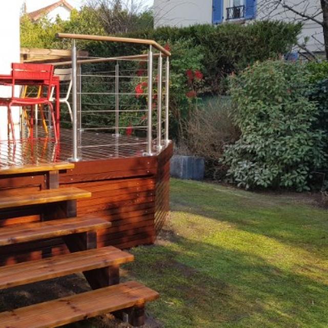 Terrasse en hauteur et aménagement d'un espace bûcher bois.